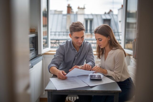 Un couple examine des documents pour acheter un appartement à Paris