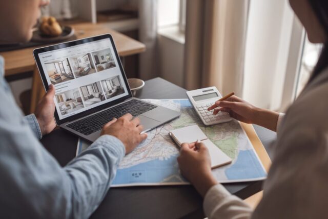 Un couple compare annonces immobilières et carte d’Île-de-France sur une table