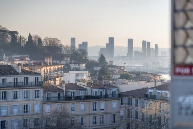 Vue de la Croix-Rousse à Lyon avec immeubles et panneau immobilier